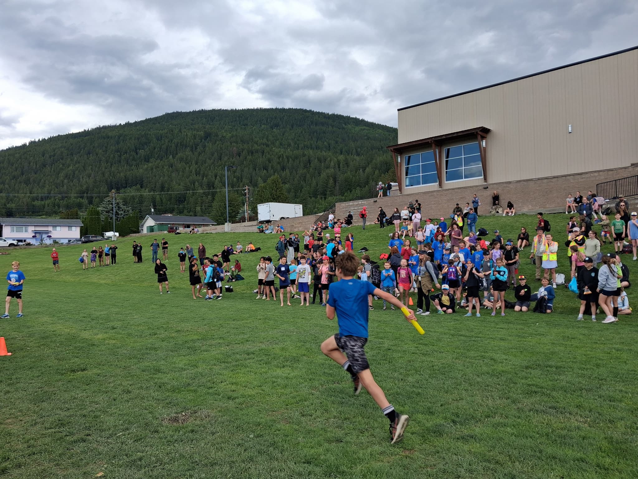 students running relay race, many other students watching